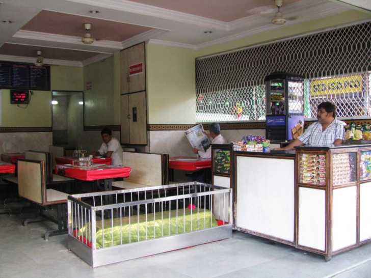View inside the restaurant, with a grave near the cash register.
Eat Among the Graves in this Restaurant in India